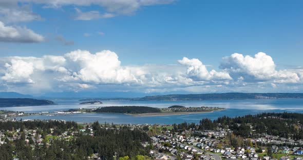 Aerial shot of Whidbey Island's Oak Harbor surrounded by clouds on a warm summer's day. alt