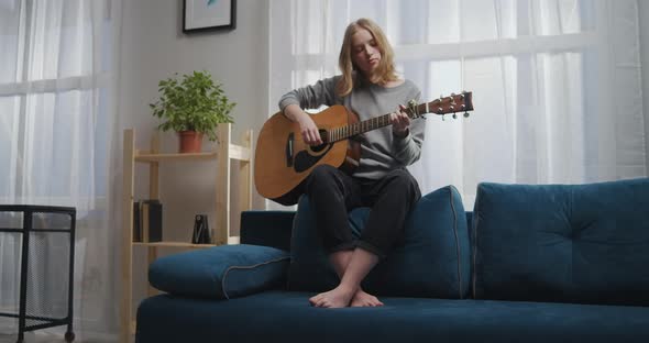The Girl Plays the Guitar on the Couch alt