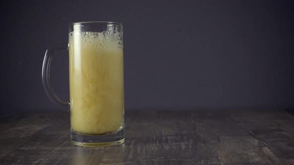 Slow Motion Pour Light Beer in a Mug on a Grey Background