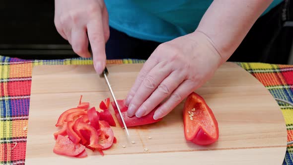 Senior Caucasian Woman Cut Sweet Red Bell Pepper on Wooden Cutting Board