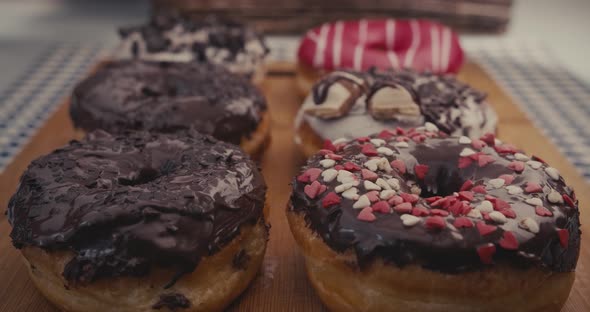 Six glossy donuts on a plate with a moving reflection