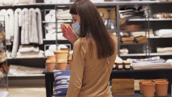 Long Haired Lady in Disposable Face Mask Walks Along Store alt