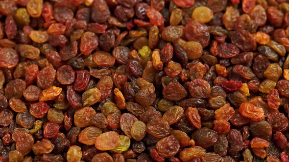 Looped Spinning Full Frame Background of Yellow and Brown Raisins Pile alt