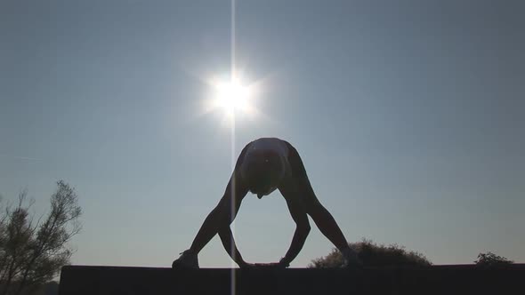 Woman Stretching in Front of Sun