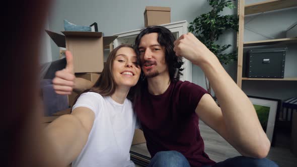 POV of Husband and Wife Taking Selfie with New Flat Keys Kissing and Posing alt
