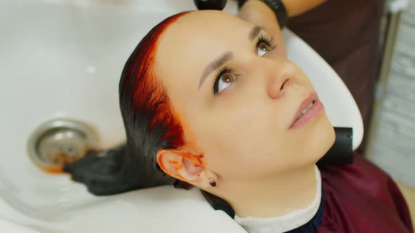 Young Woman Sits Putting Head Over Sink During Hair Care Procedure in Salon alt