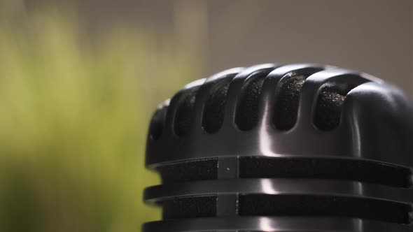 Extremely Close Up View of Top of Retro Microphone That is Spinning alt