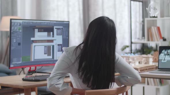 Asian Woman Engineer Having A Backache While Designing House On A Desktop At Home alt