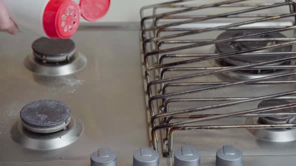 Cleaning and tidying the household gas stove. A man polishes his gas stove alt