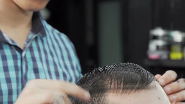 Cropped Shot of a Hairstylist Combing Wet Hair of a Client