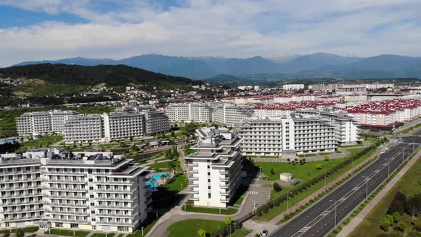 Panorama of City Buildings and Park. A Drone Flies Over the Roofs of City Buildings. Below We See a