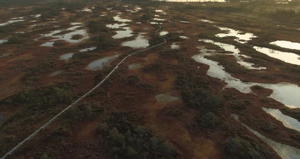Aerial View of Bog Lakes and Wooden Boardwalk Hiking Trail at Sunrise alt