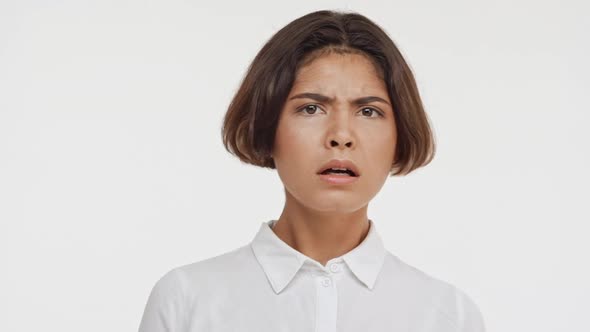 Young Beautiful Brunette East Asian Female in Shirt Frighting and Disapproving on White Background alt