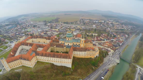 Aerial Shot of Beautiful Baroque Abbey Standing Atop Town Melk and River Danube alt
