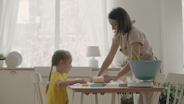 Mom and Daughter Roll Out the Dough in the Kitchen