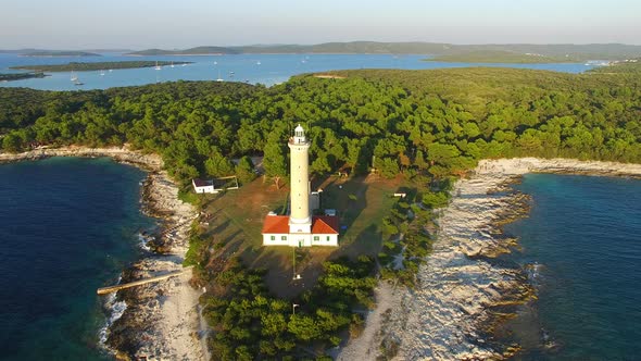 Flying over lighthouse, Croatia with a forest in the background alt