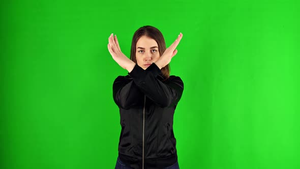 Woman Showing a Stop Arms Crossed On a Green Screen