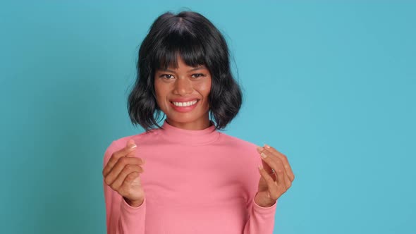 Young Woman Makes Money Gesture Has Idea of Big Profit Against Blue Background alt