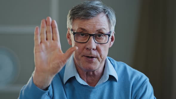 Serious Old Senior Mature 60s Man Stretch Out Palm to Camera Says Stop Gesture Indoors alt