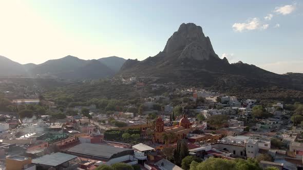 Picturesque Town Of Bernal, Queretaro With The Peña de Bernal Monolith In The Background - aerial dr alt