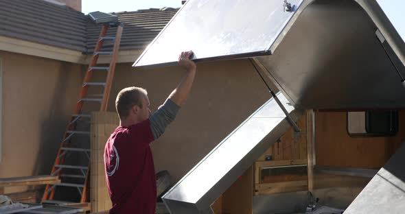 A custom travel trailer construction worker opening and raising the hatch back on the metal teardrop alt