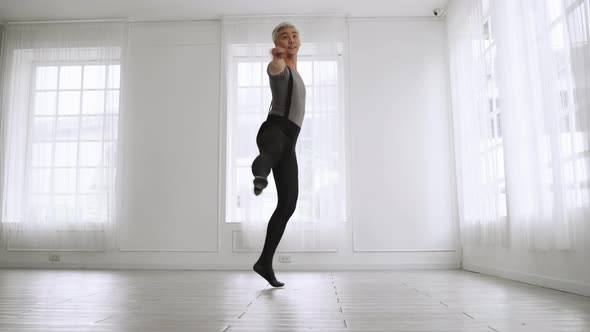 young Asian ballet dancer practicing in a room alone.