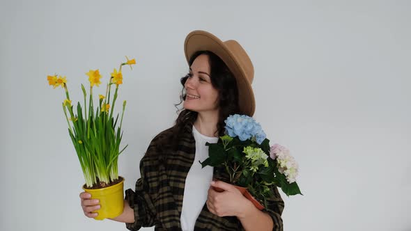 Beautiful Young Woman Florist with Flowers on White Background Smiling at Camera
