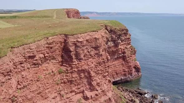 STATIC CROP, Rising Aerial of sandstone cliffs along the Jurassic Coast in Devon, UK alt