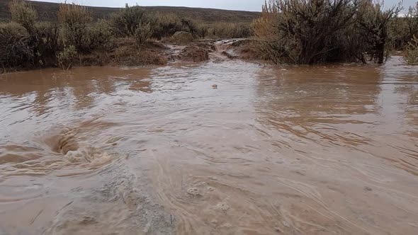 Panning over flood water being suctioned into whirlpool after rain ...