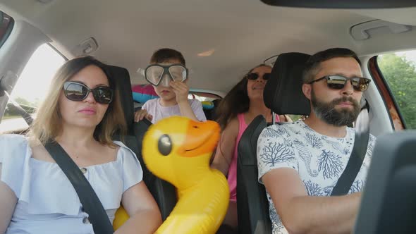 Children are Happy to Travel on Vacation at Sea While Sitting in the Back Seats in the Car alt
