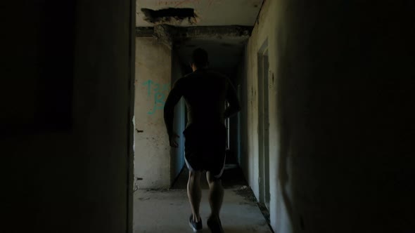 Unrecognizable Sportsman Running Through Derelict Building