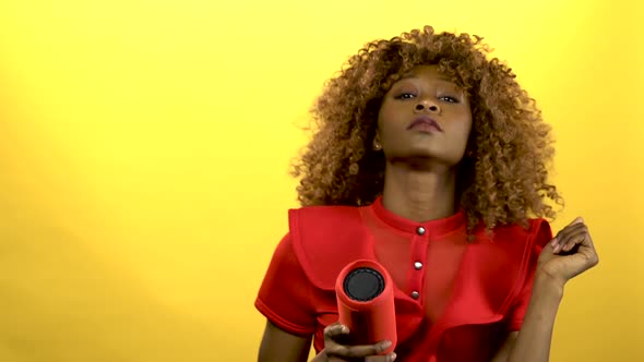 Girl of African American Woman Holding a Player and Dancing .Yellow Background alt