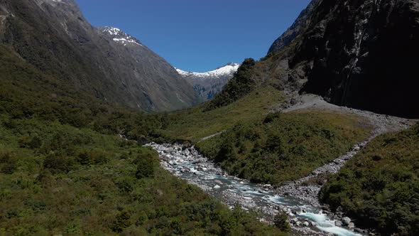 Fast mountain river in rocky narrow valley below mountain peaks in Fiordland Southland, New Zealand. alt