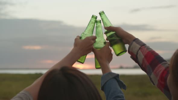 Group of a young Asian women happy friends camping in nature having fun together drinking beer.