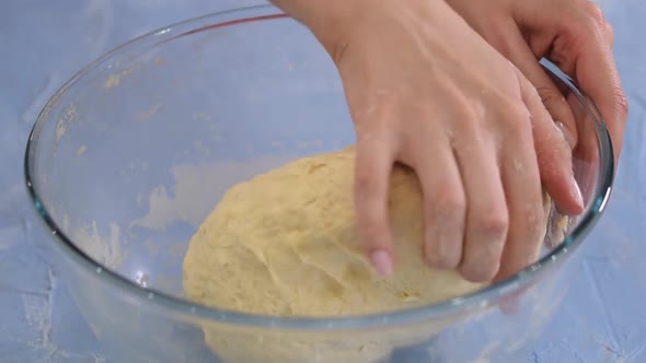 Hands Kneading Bread Dough in Glass Bowl