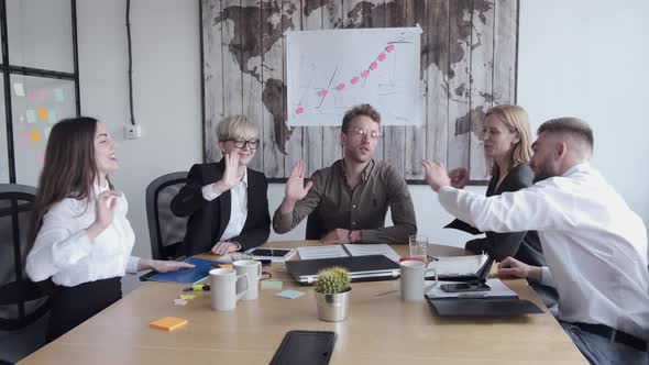 The Office Workers Are Raising Hands in Satisfaction Sitting at the Table alt