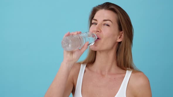 Portrait of an Energetic Female Drinking Water from a Bottle