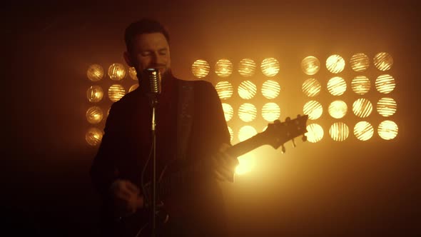 Handsome Guitarist Singing Microphone in Night Club alt