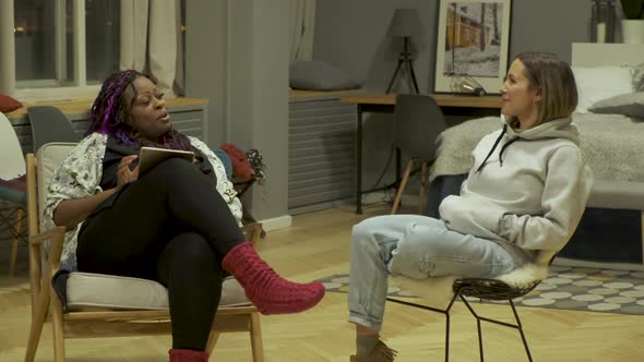 An African American woman Uses a tablet And a European Woman they Communicate Discuss  alt