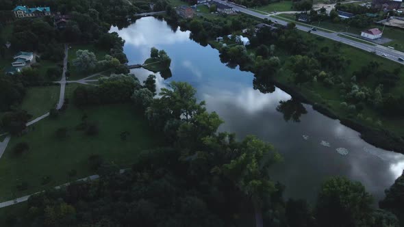 City park with a reservoir. A bridge leads to the island. Aerial photography at dusk. alt