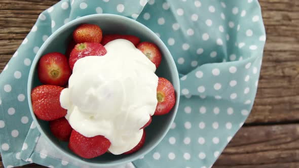 Overhead of fresh strawberries with cream in bowl alt