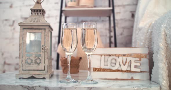 Closeup Of Two Bubbling Champagne Glasses Against The Backdrop Of Festive Decorations, Lights And alt