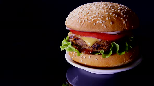 Appetizing burger on a black background. Delicious fast food.