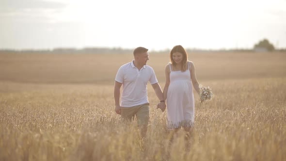 Beautiful Couple with Pregnant Woman in Forest.