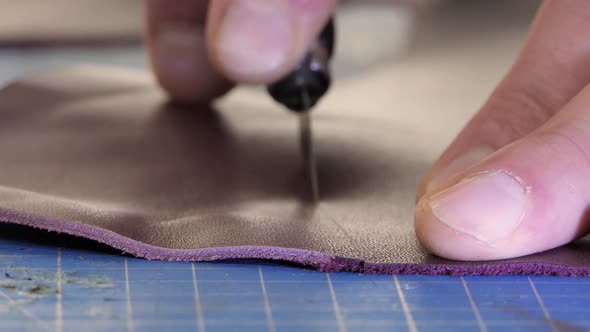 A Male Tailor Cuts Artificial Leather Closeup