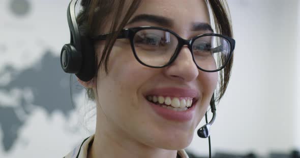 Close Up of Beautiful Young Operator Woman Standing and Wearing Headset at the Bright Office Space alt