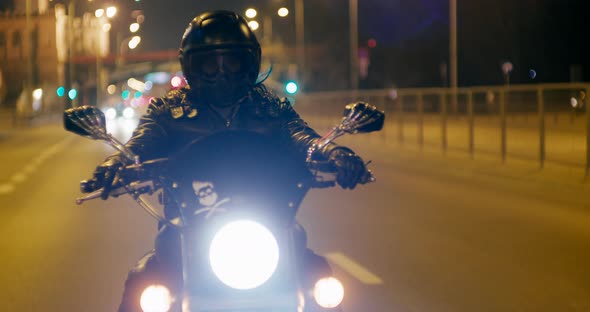 Biker is Riding Motorcycle on City Roads at Night