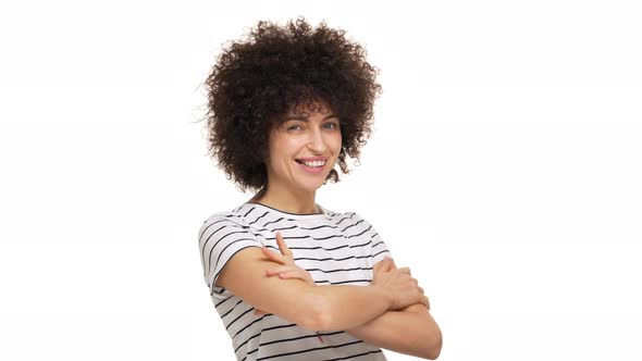 Close Up Portrait of Joyful Young Woman with Tricky Look Standing on Camera with Arms Folded alt
