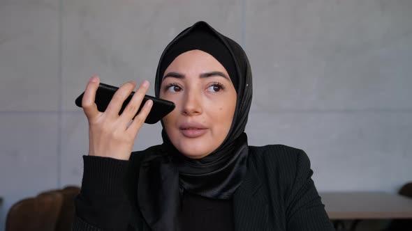 Business Muslim Woman in Hijab Leaves a Voice Message on the Mobile Phone