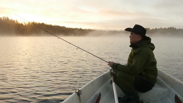 Fisherman Trolling Fish on Lake Early Morning